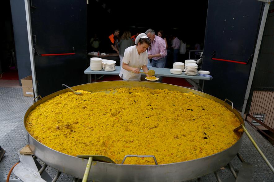 Cocinera sirviendo paella. 