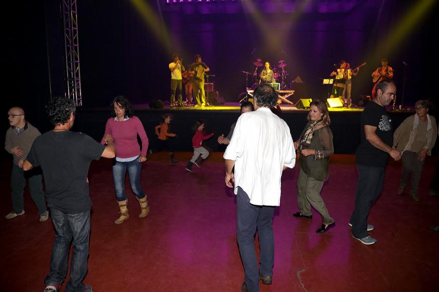 Gala a Favor de la Asociación Enfermos de Parkinson ALCOSSE - Imagen de personas bailando, mientras en el escenario actúa un grupo de música.
