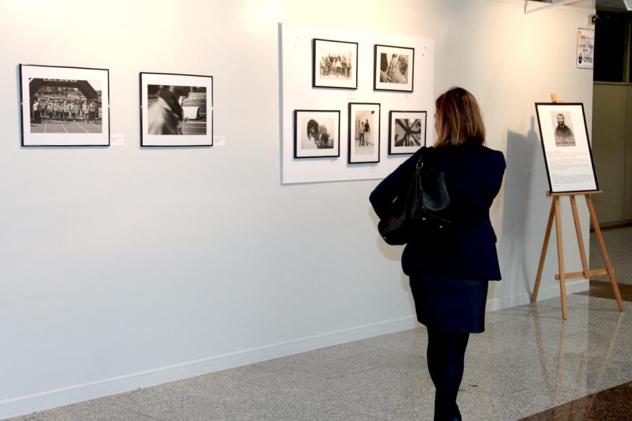 Inauguración Fotográfica sobre el Parkinson en el Patio de Encuentros - Imagen de una persona mirando la exposición.