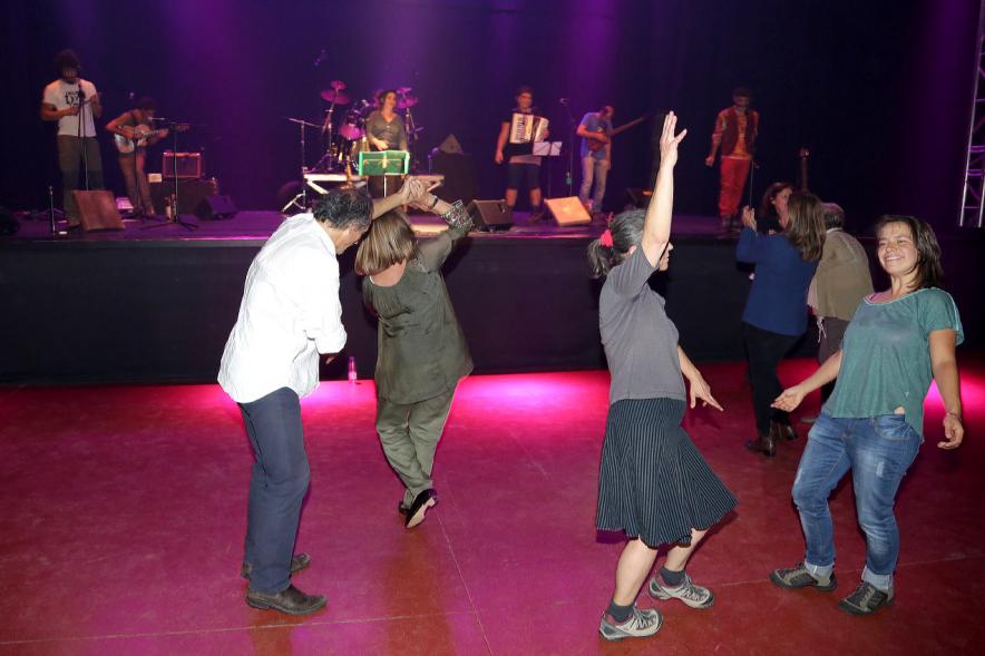 Gala a Favor de la Asociación Enfermos de Parkinson ALCOSSE - Imagen de personas bailando, mientras en el escenario actúa un grupo de música.