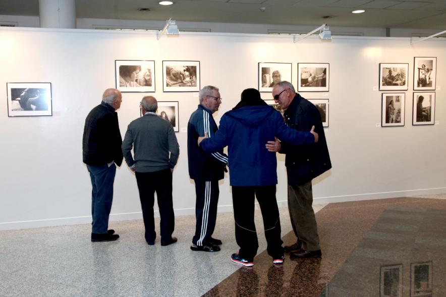 Inauguración Fotográfica sobre el Parkinson en el Patio de Encuentros - Imagen de personas mirando la exposición.