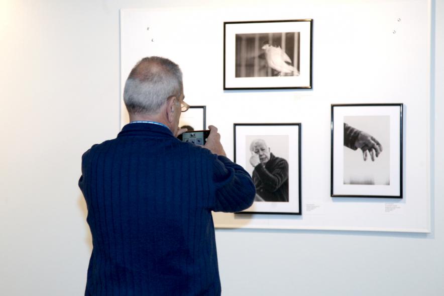 Inauguración Fotográfica sobre el Parkinson en el Patio de Encuentros - Imagen de una persona mirando la exposición.