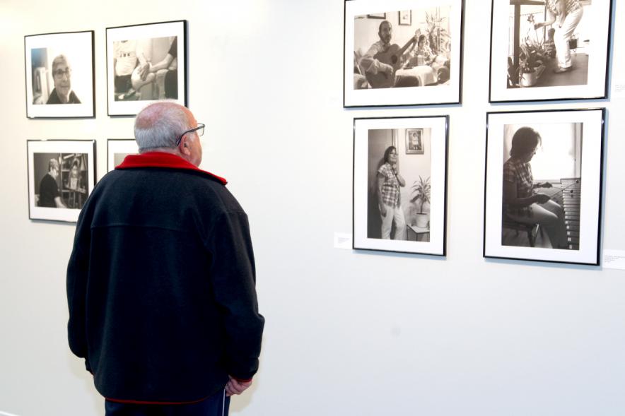 Inauguración Fotográfica sobre el Parkinson en el Patio de Encuentros - Imagen de una persona mirando la exposición.