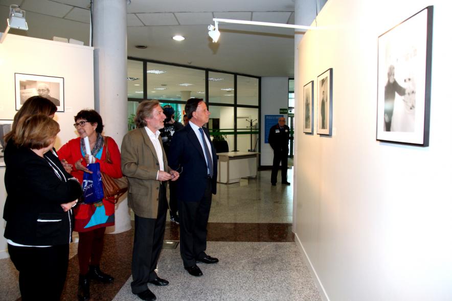 Inauguración Fotográfica sobre el Parkinson en el Patio de Encuentros - Imagen del autor Carlos Carneiro y el alcalde García de Vinuesa y otras personas recorriendo la exposición.