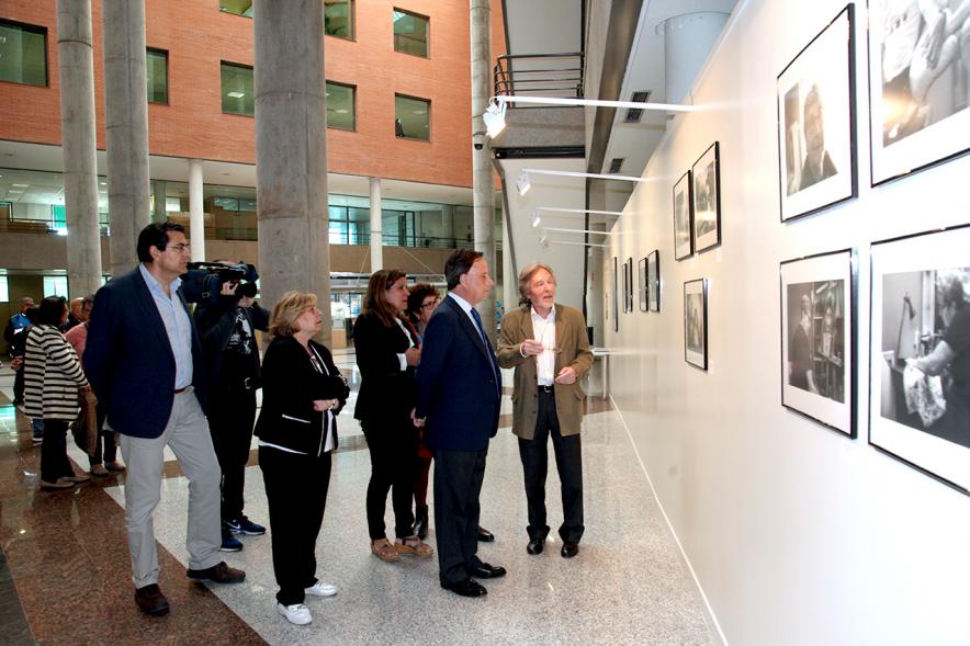 Inauguración Fotográfica sobre el Parkinson en el Patio de Encuentros - Imagen del autor Carlos Carneiro y el alcalde García de Vinuesa y otras personas recorriendo la exposición.