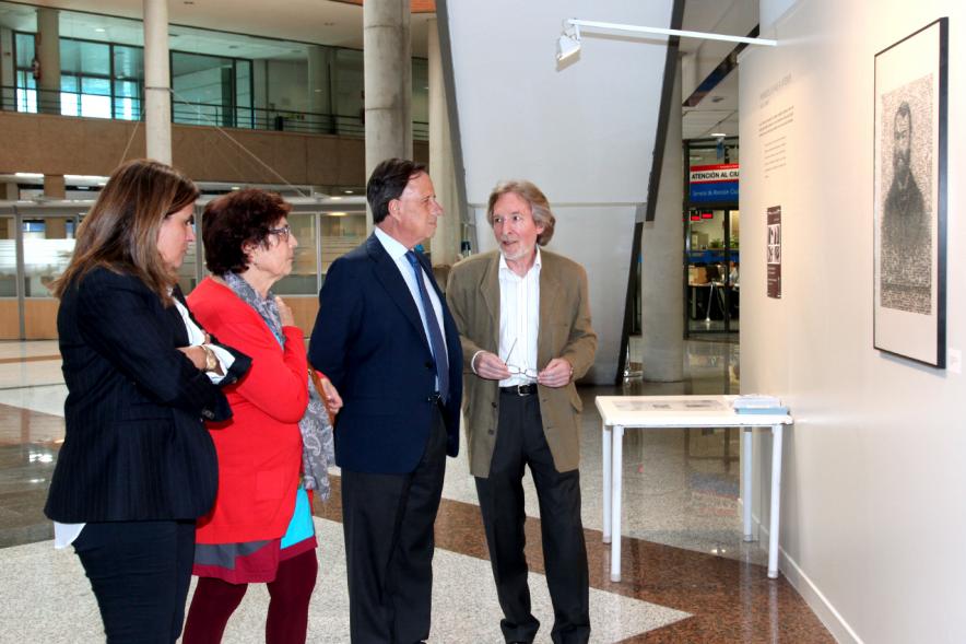 Inauguración Fotográfica sobre el Parkinson en el Patio de Encuentros - Imagen del autor Carlos Carneiro y el alcalde García de Vinuesa y otras personas recorriendo la exposición.