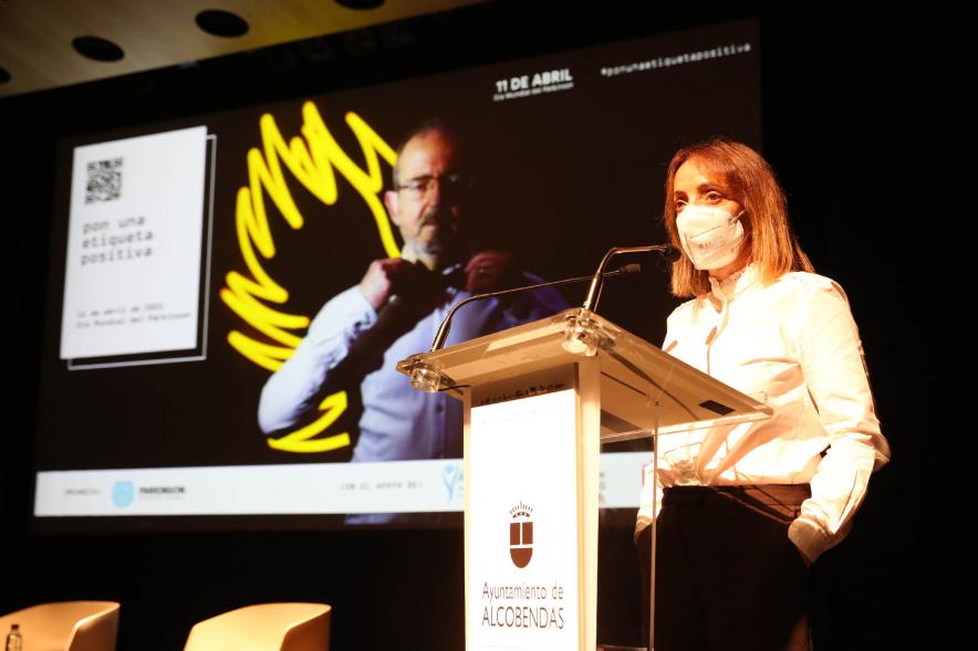 Día Mundial del Parkinson - Imagen de una ponente hablando sobre el Día Mundial del Parkinson con ayuda de un PowerPoint.