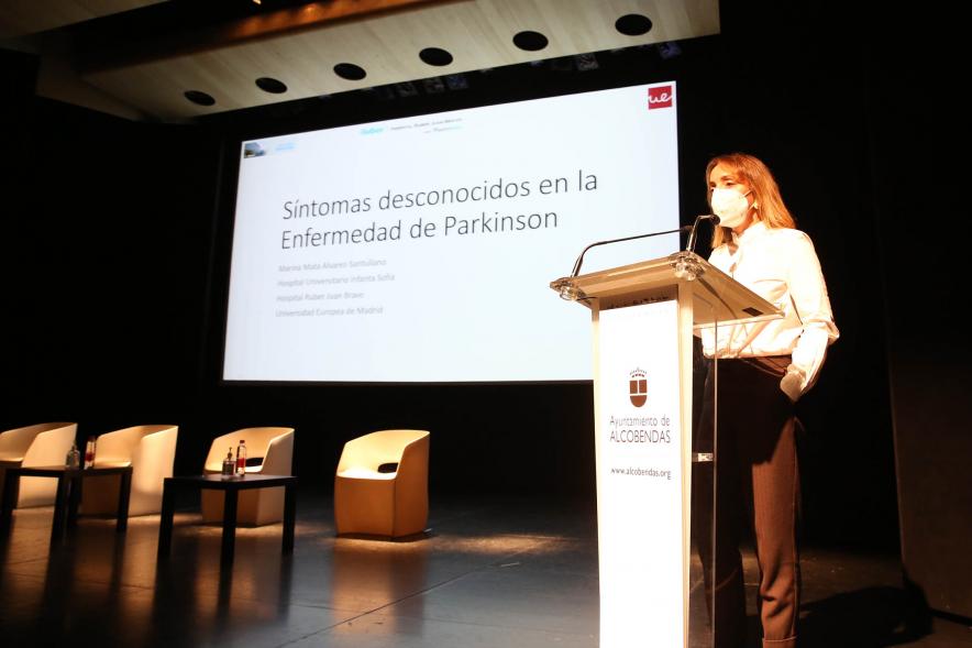 Día Mundial del Parkinson - Imagen de una ponente hablando sobre el Día Mundial del Parkinson con ayuda de un PowerPoint.