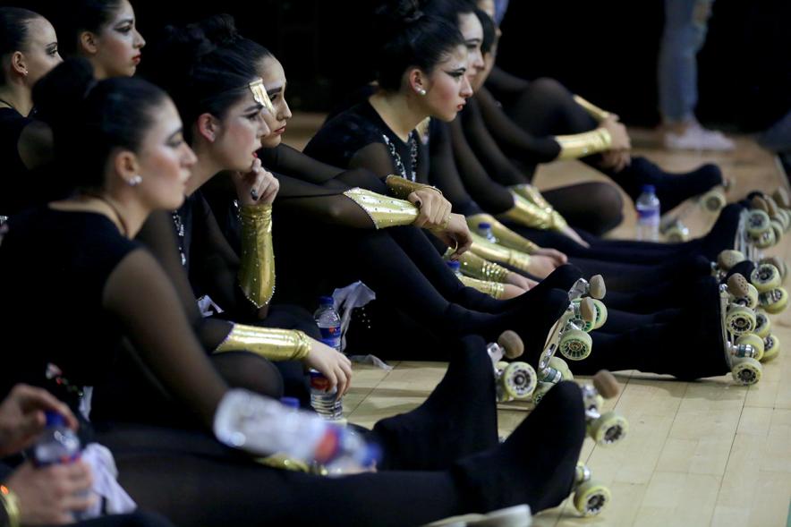 Campeonato Autonómico de Patinaje - Grupos Patinaje Show - Imagen de patinadoras sentadas en el suelo viendo una actuación.