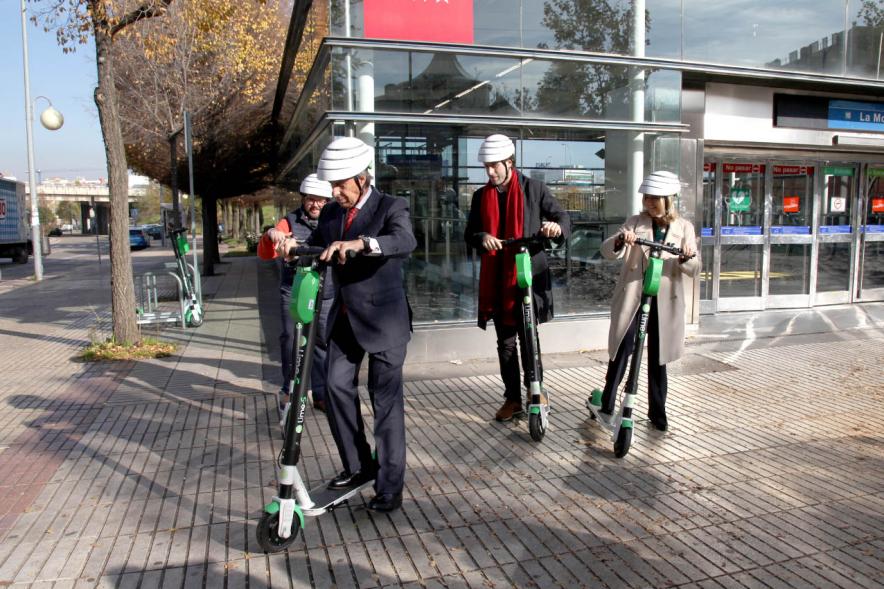 Presentación Patinetes Eléctricos Empresa LIme España - Imagen del alcalde García de Vinuesa montado en un patinete, seguido de otras autoridades.
