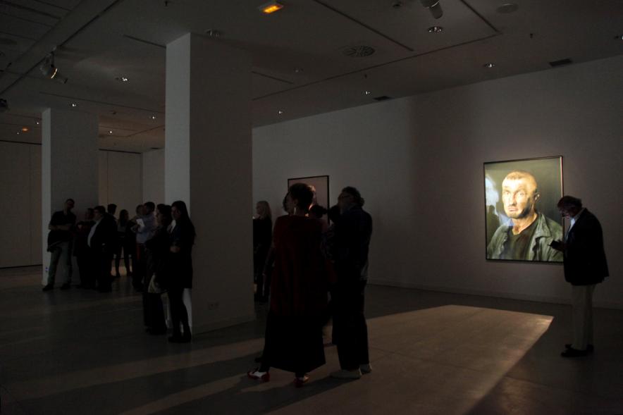 Sala oscura, con obra iluminada al fondo