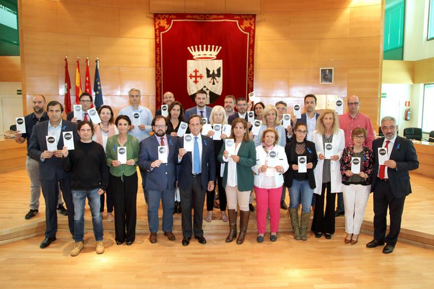 Pleno municipal al completo posando con folleto