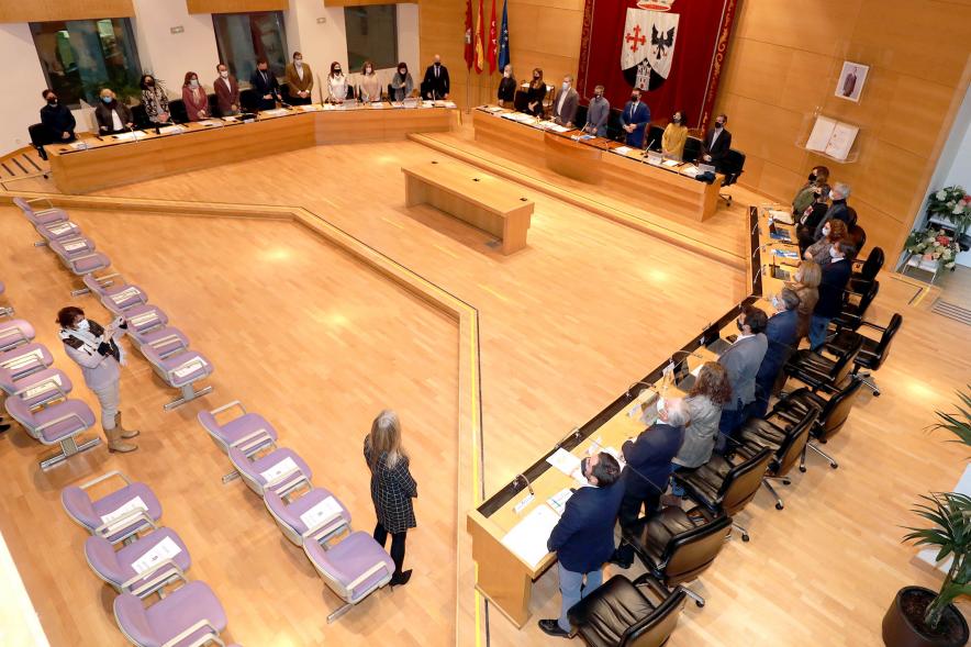 Vista cenital del salón de plenos con concejales en pie durante la pandemia de COVID 19