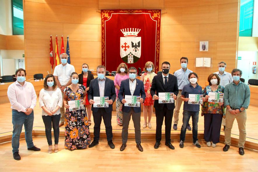 Pleno municipal al completo posando con folleto