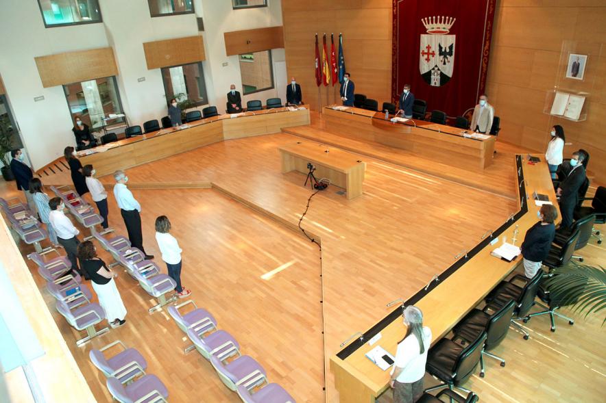 Vista cenital del salón de plenos con concejales en pie durante la pandemia de COVID 19