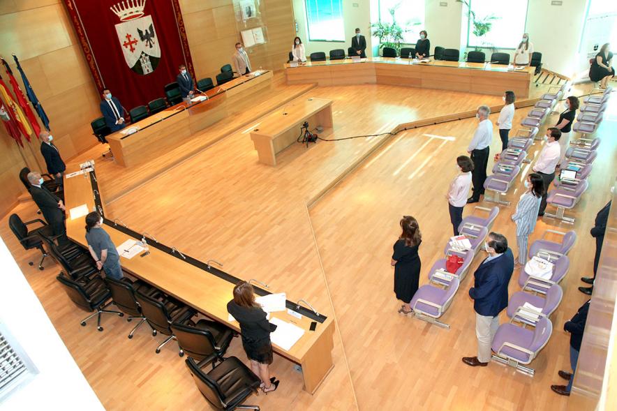 Vista cenital del salón de plenos con concejales en pie durante la pandemia de COVID 19