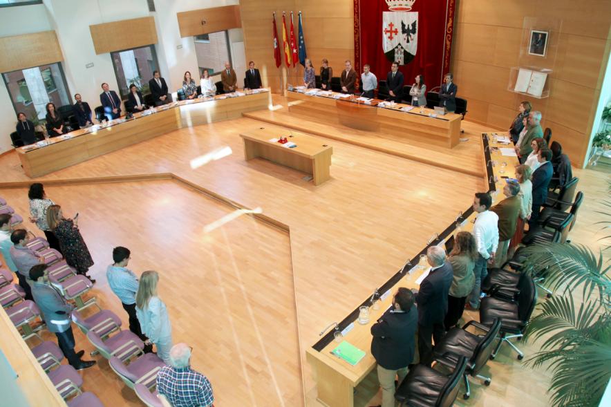 Vista cenital del salón de plenos con concejales en pie