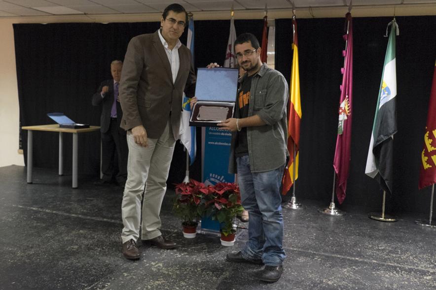 Entrega de Premios del XVº Certamen de Poesía de las Casas Regionales - Imagen de persona entregando una placa a un homenajeado.