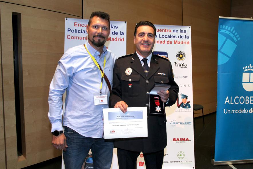 Ier Encuentro de las Policías Locales de la Comunidad de Madrid - Imagen de una persona recibiendo un diploma de mano de una autoridad.