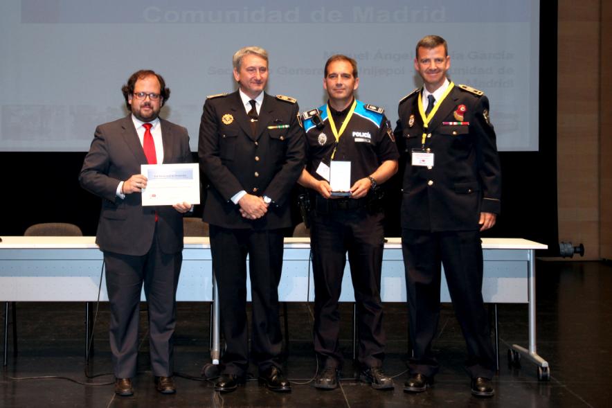 Ier Encuentro de las Policías Locales de la Comunidad de Madrid - Imagen de una persona recibiendo un diploma de mano de una autoridad.