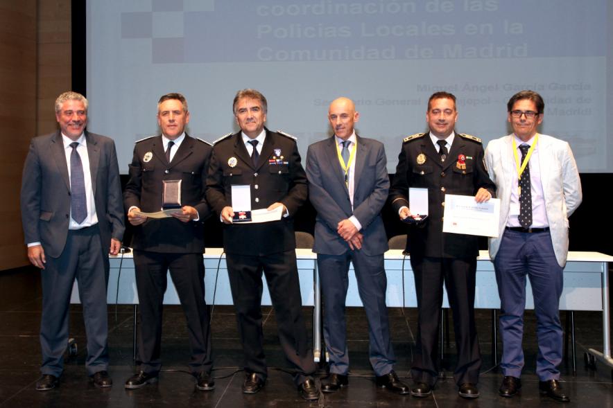 Ier Encuentro de las Policías Locales de la Comunidad de Madrid - Imagen de unas personas recibiendo  diplomas de mano de una autoridad.