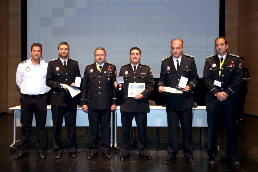 Ier Encuentro de las Policías Locales de la Comunidad de Madrid - Imagen de unas persona recibiendo los diplomas de mano de una autoridad.