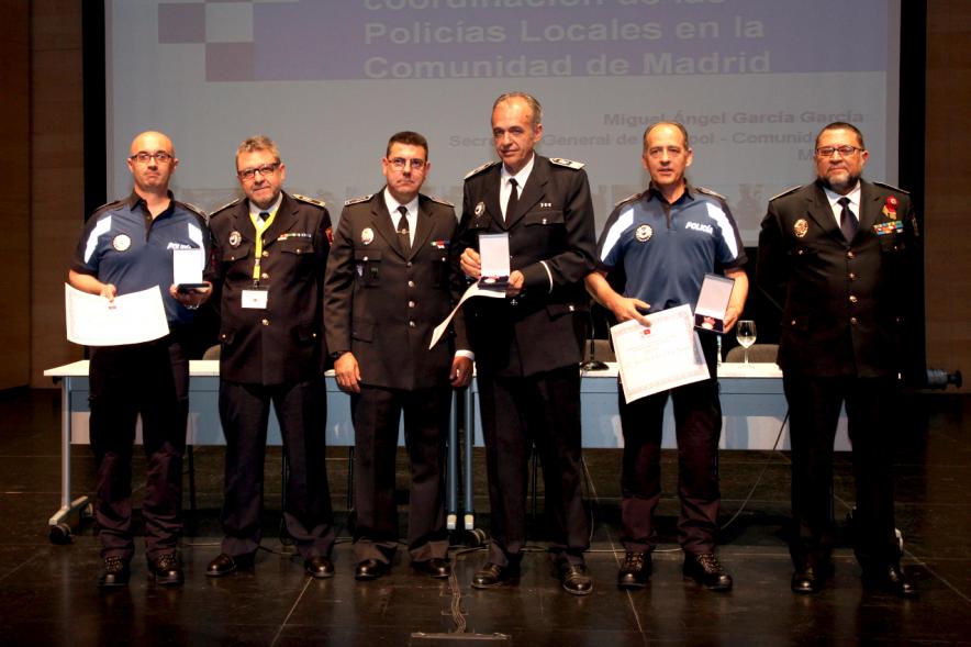 Ier Encuentro de las Policías Locales de la Comunidad de Madrid - Imagen de unas persona recibiendo los diplomas de mano de una autoridad.