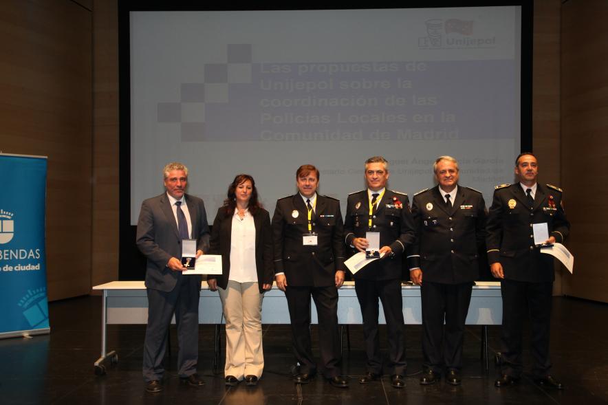 Ier Encuentro de las Policías Locales de la Comunidad de Madrid - Imagen de unas persona recibiendo los diplomas de mano de una autoridad.