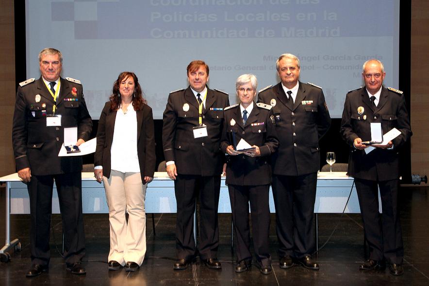Ier Encuentro de las Policías Locales de la Comunidad de Madrid - Imagen de unas persona recibiendo los diplomas de mano de una autoridad.