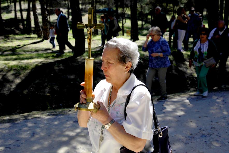 Mujer con cruz abriendo la romería