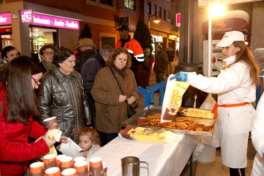Pregón Fiestas Virgen de la Paz 2019 - Imagen del público cogiendo churros en una churrería ambulante.