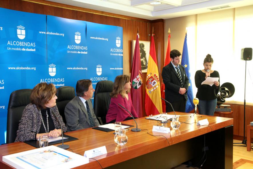 Premio Mención de Excelencia como Ciudad Amiga de la Infancia - Imagen lateral de la mesa de los  ponentes  y los jóvenes leyendo. 
