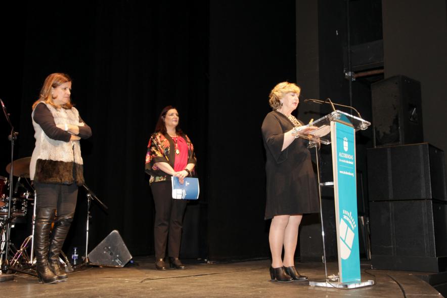 Entrega Premios Atenea y Hombres por la Igualdad 2018 - Imagen de una mujer dirigiéndose al público asistente al acto y otras personas en el escenario.