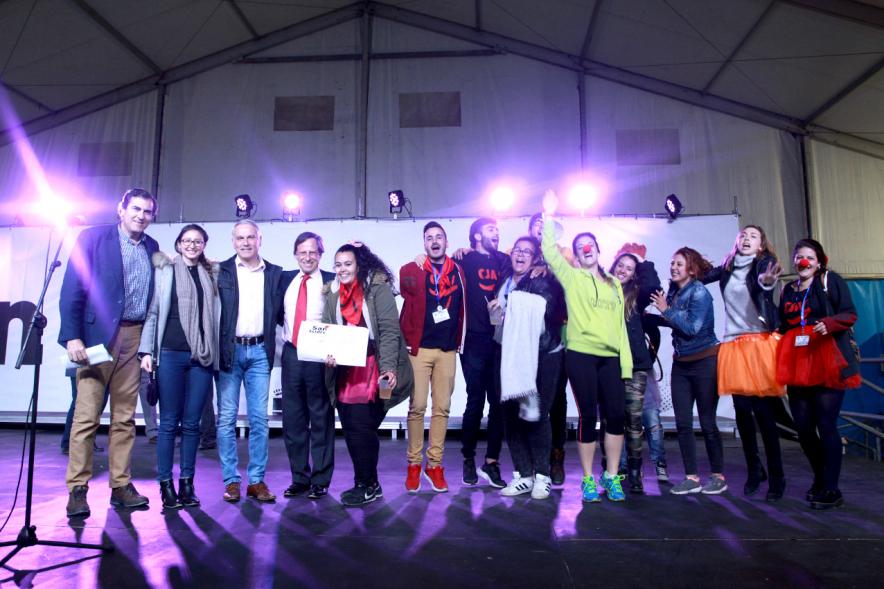 Participantes y autoridades posando con el premio en escenario