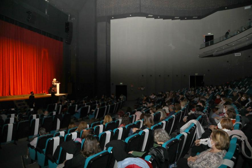 Entrega de Premios Atenea y Hombres por la Igualdad 2021 - Imagen del auditorio, con las medidas de seguridad. En el escenario iluminado la presentadora.