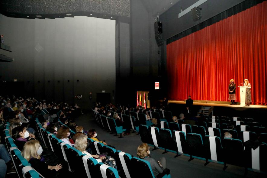Entrega de Premios Atenea y Hombres por la Igualdad 2021 - Imagen lateral del patio de butacas, del escenario con la premiada y la responsable de Igualdad del Ayuntamiento.
