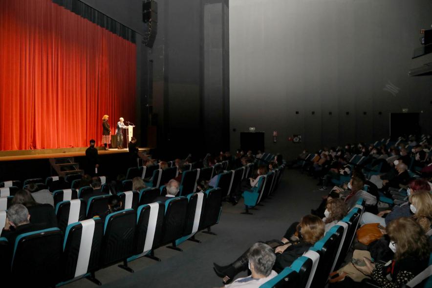 Entrega de Premios Atenea y Hombres por la Igualdad 2021 - Imagen del auditorio, con las medidas de seguridad. En el escenario iluminado la presentadora.