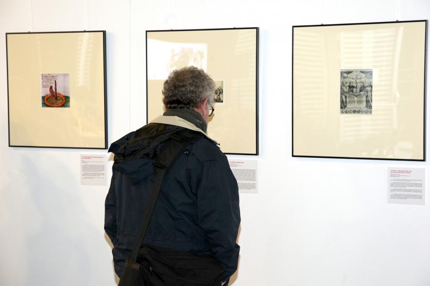 Presentación Libro "Imperiofobia y Leyenda Negra" e Inauguración Exposición Ilustraciones Martín Lutero - Imagen de un visitante junto a la obra gráfica.