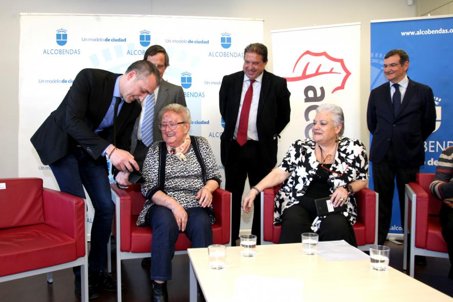 Presentación Proyecto Piloto Familyar Social Service - Imagen de unas personas mayores recibiendo el dispositivo que se esta presentando en el acto.