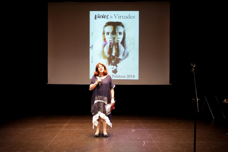 Presentación del Libro Sinfonía de Palabras 2018 y Entrega Premio Ganador Certamen MIcrorrelatos - Primer plano del escenario con la presentadora  con el fondo del cartel del acto.