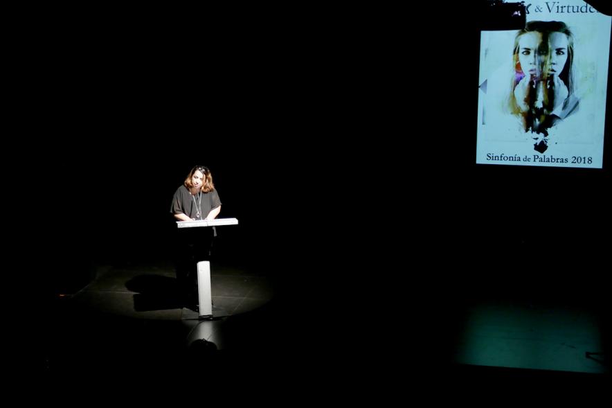 Presentación del Libro Sinfonía de Palabras 2018 y Entrega Premio Ganador Certamen MIcrorrelatos - Panorámica del escenario oscurecido  con la presentadora.