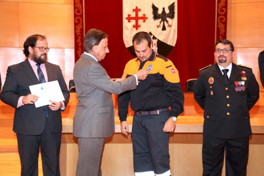 Entrega de Medallas al Mérito de Protección Civil - Imagen unas autoridades y del alcalde García de Vinuesa concediendo su medalla a un condecorado.