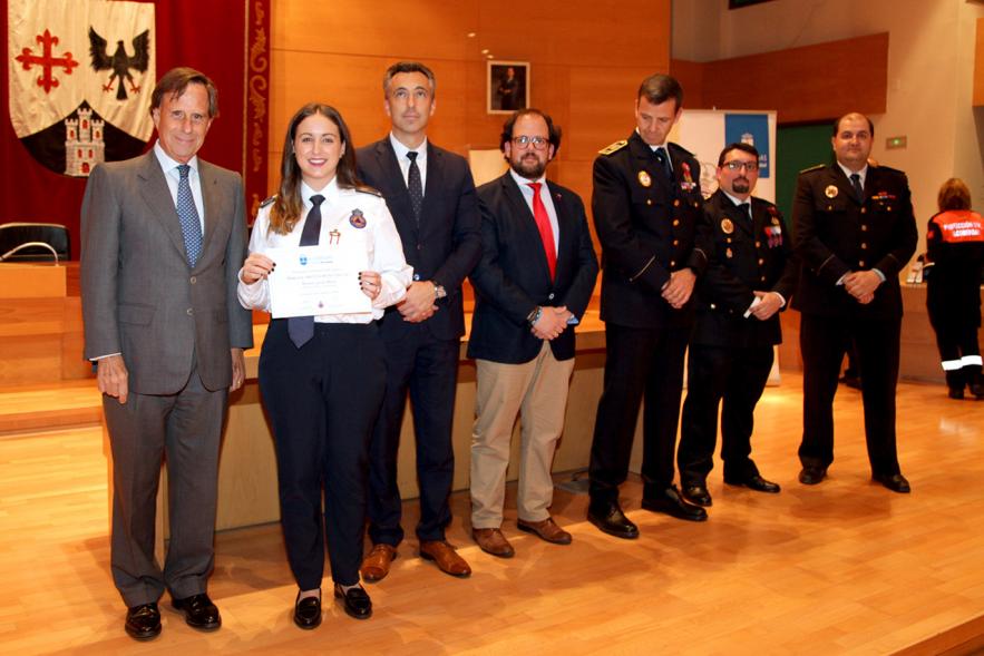 Entrega de Medallas de Protección Civil 2018 -  Imagen de una miembra de Protección Civil posando con su medalla y su diploma posando junta a las autoridades que se lo han entregado, entre ellas el alcalde García de Vinuesa.
