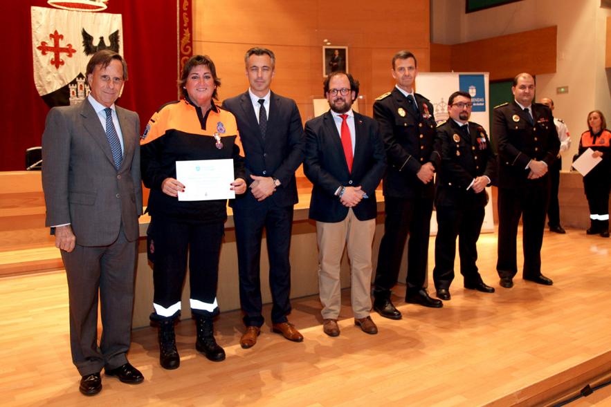 Entrega de Medallas de Protección Civil 2018 - Imagen de una miembra de Protección Civil posando con su medalla y su diploma posando junta a las autoridades que se lo han entregado, entre ellas el alcalde García de Vinuesa.