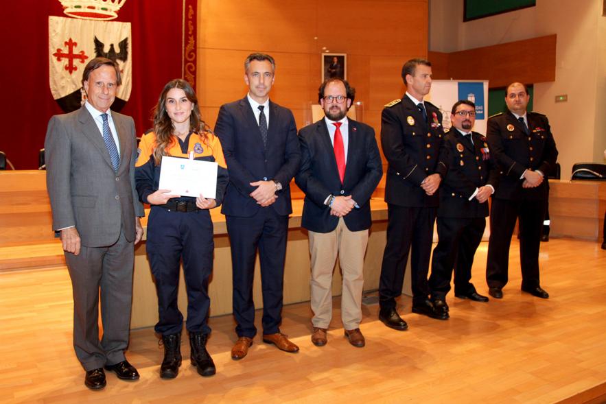 Entrega de Medallas de Protección Civil 2018 - Imagen de una miembra de Protección Civil posando con su medalla y su diploma posando junta a las autoridades que se lo han entregado, entre ellas el alcalde García de Vinuesa.