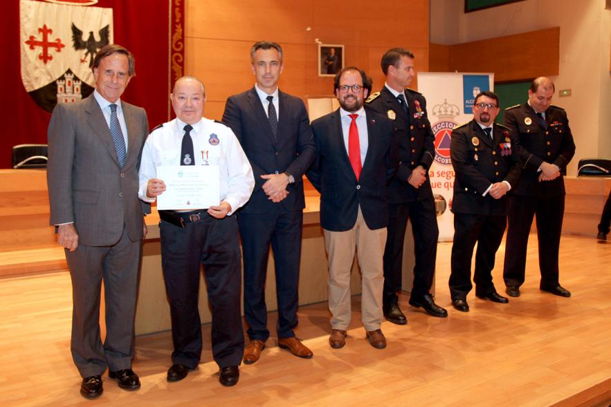 Entrega de Medallas de Protección Civil 2018 - Imagen de un miembro de Protección Civil posando con su medalla y su diploma posando junta a las autoridades que se lo han entregado, entre ellas el alcalde García de Vinuesa.