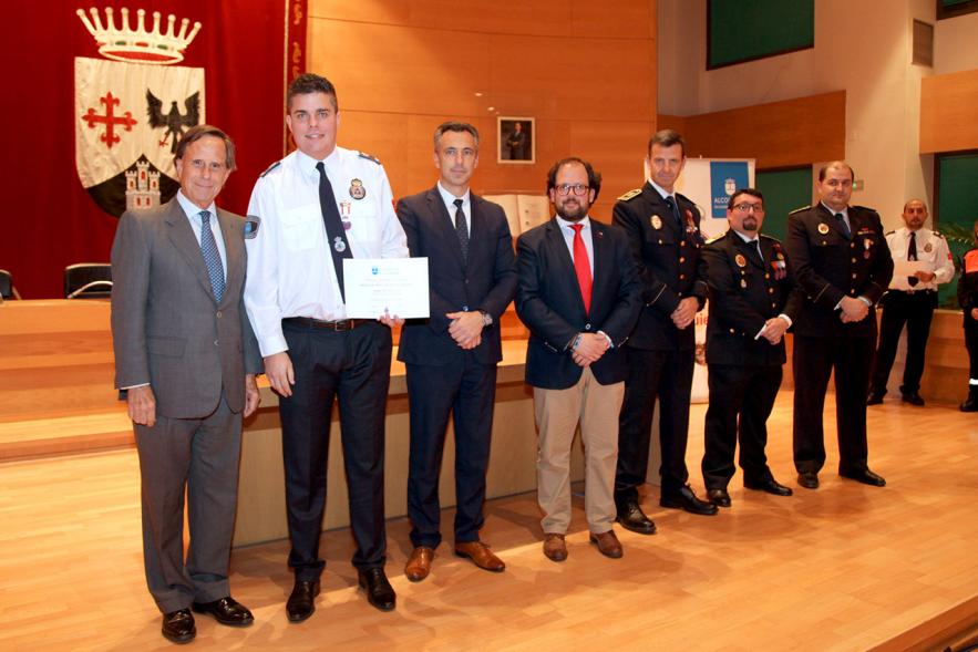Entrega de Medallas de Protección Civil 2018 - magen de un miembro de Protección Civil posando con su medalla y su diploma posando junta a las autoridades que se lo han entregado, entre ellas el alcalde García de Vinuesa.