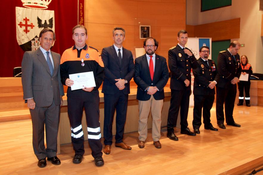 Entrega de Medallas de Protección Civil 2018 - Imagen de un miembro de Protección Civil posando con su medalla y su diploma posando junta a las autoridades que se lo han entregado, entre ellas el alcalde García de Vinuesa.