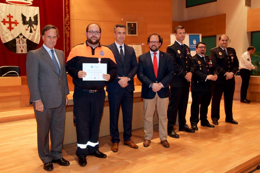 Entrega de Medallas de Protección Civil 2018 - Imagen de un miembro de Protección Civil posando con su medalla y su diploma posando junta a las autoridades que se lo han entregado, entre ellas el alcalde García de Vinuesa.