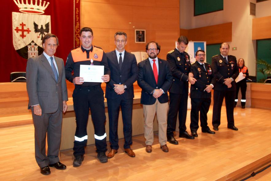 Entrega de Medallas de Protección Civil 2018 - Imagen de una miembra de Protección Civil posando con su medalla y su diploma posando junta a las autoridades que se lo han entregado, entre ellas el alcalde García de Vinuesa.